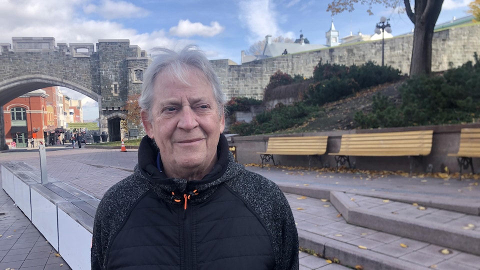 Un homme aux cheveux gris debout dans un parc.