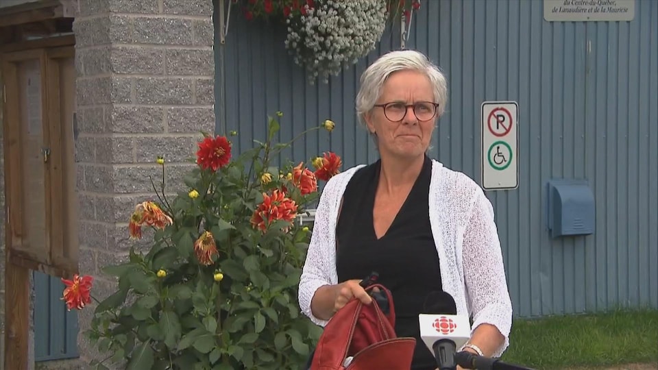 Une dame qui porte des lunettes, qui a les cheveux blancs, qui porte un chandail noir et blanc, en entrevue à Radio-Canada.