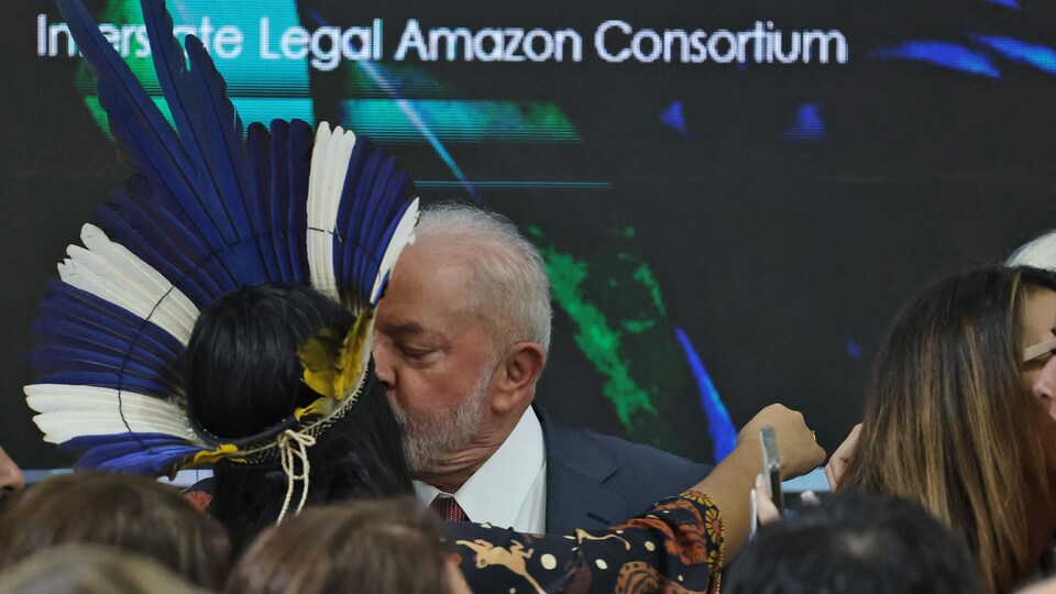 Luiz Inacio Lula da Silva embrasse une personne portant une tenue amérindienne