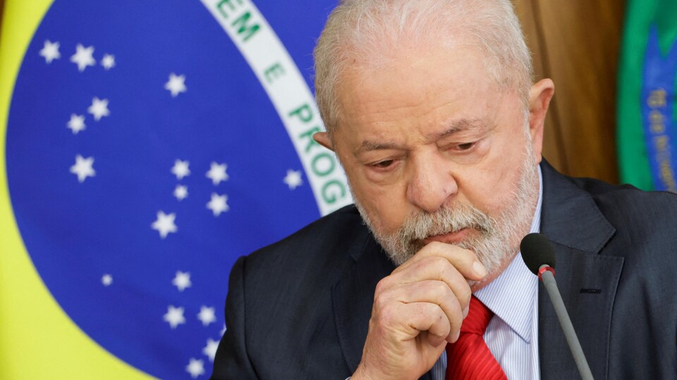 Portrait de Lula devant le drapeau brésilien.