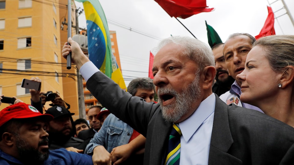 L'ex-président Lula, brandissant un drapeau du Brésil à son arrivée au tribunal.