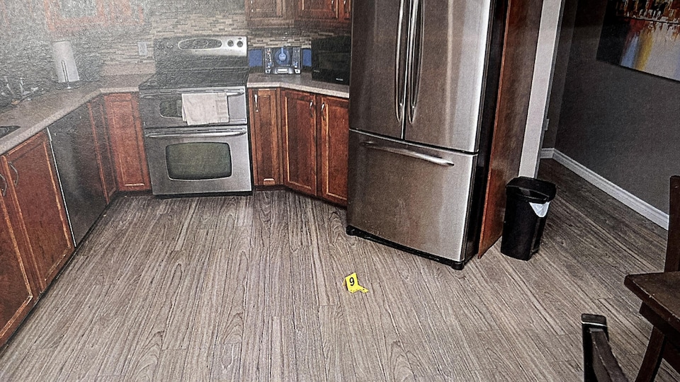 A yellow marker is placed on the kitchen floor with Mario Lafontaine.