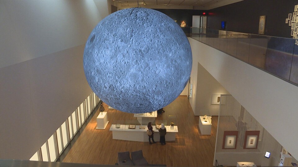 Une sculpture géante de la lune est suspendue entre les deux étages de l'exposition.