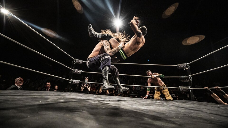 Deux lutteurs dans le ring en plein combat.