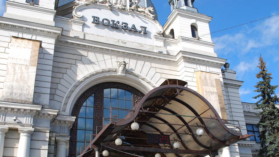 Des structures de bois protègent les statues qui ornent la devanture de la gare de Lviv.