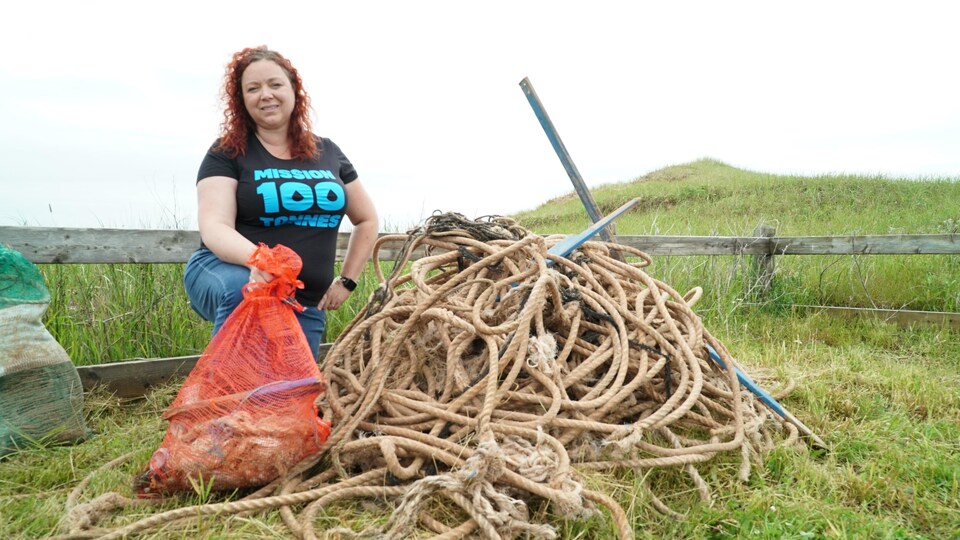 Lyne Morissette pose un genou à terre près de cordages.