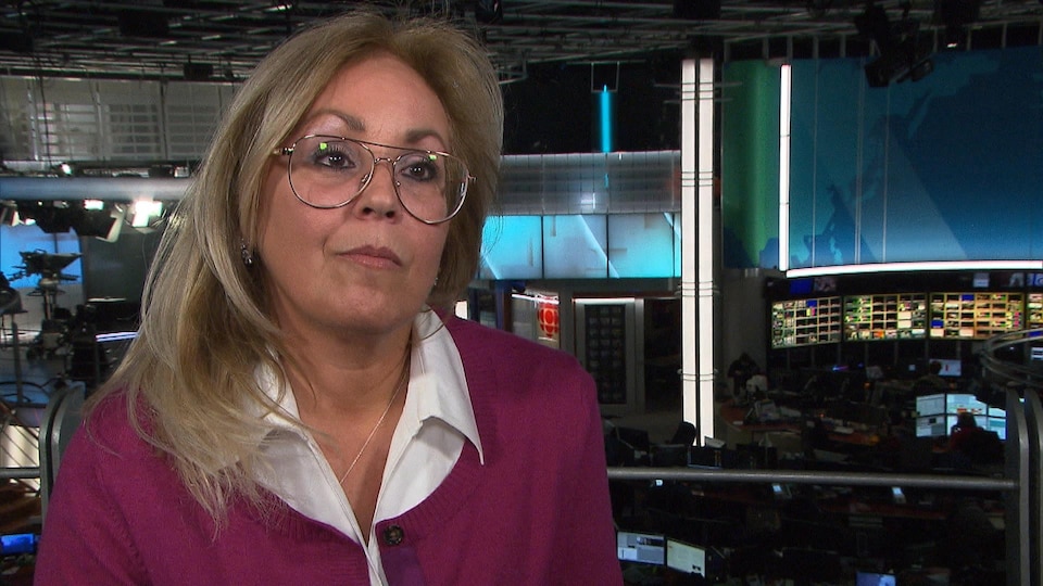 Une femme portant des lunettes est interviewé dans la salle de nouvelles de Radio-Canada.