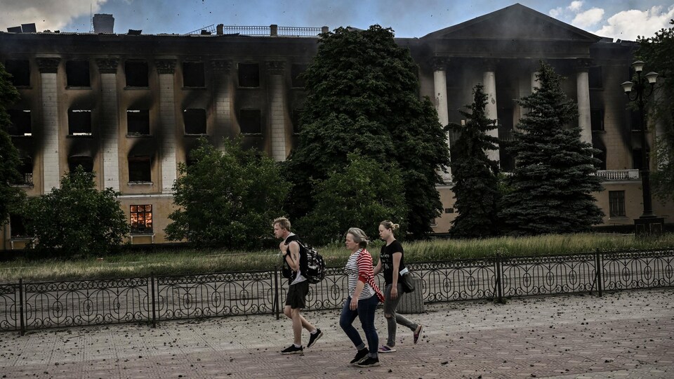 Two women and a man went through a burning building. We see the fire in the window.