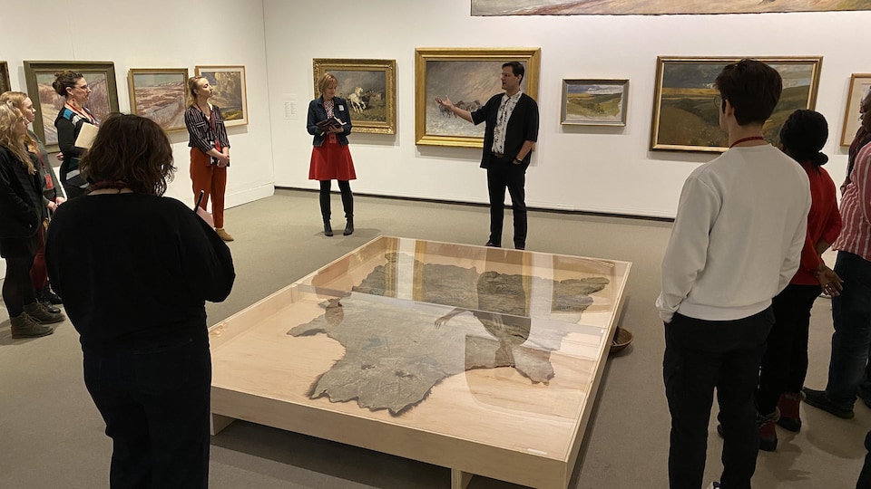 Une visite guidée d'un groupe de personnes dans la galerie d'art.