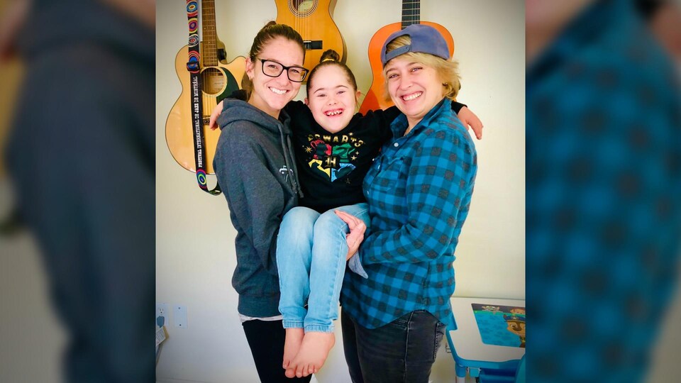 Deux mères et leur fille sourient