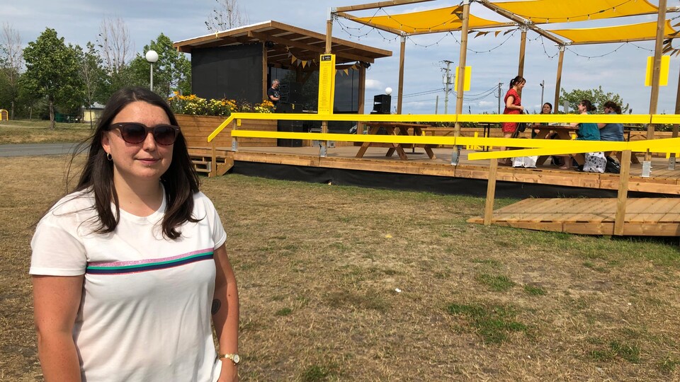 Une femme pose pour la caméra à côté de la Guinguette Chez Edmund.