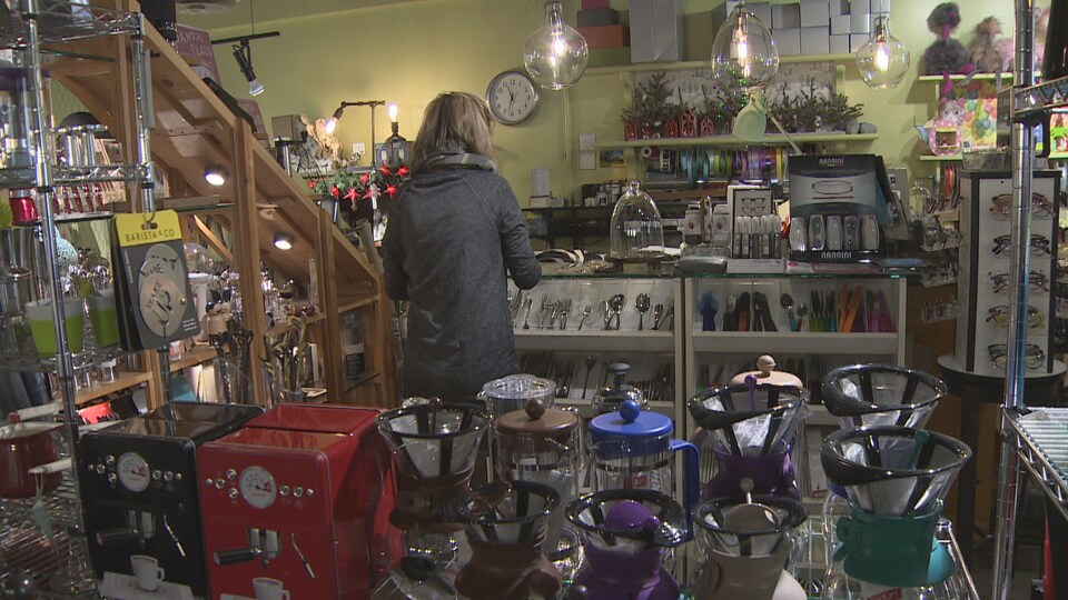 L'intérieur du magasin Chocolate Mousse dans la rue Robson avec ses cafetières et une cliente vue de dos.