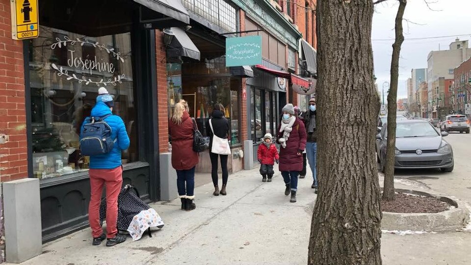 Des Sherbrookois attendent devant un magasin.