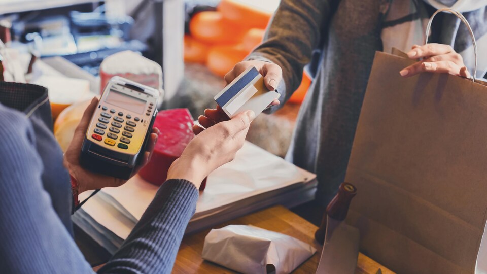 Une cliente paye son achat avec une carte de crédit