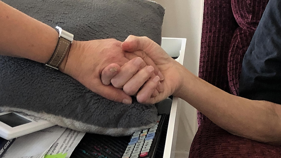 Deux personnes se tiennent la main.