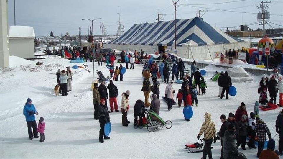 Des dizaines de personnes s'activent autour d'un chapiteau au centre-ville d'Amos, l'hiver.
