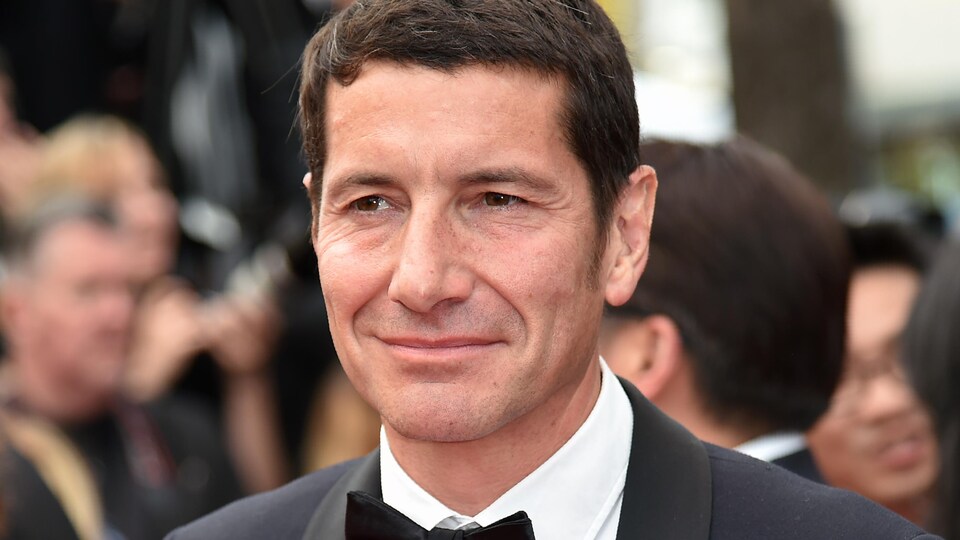 Un homme sourit.