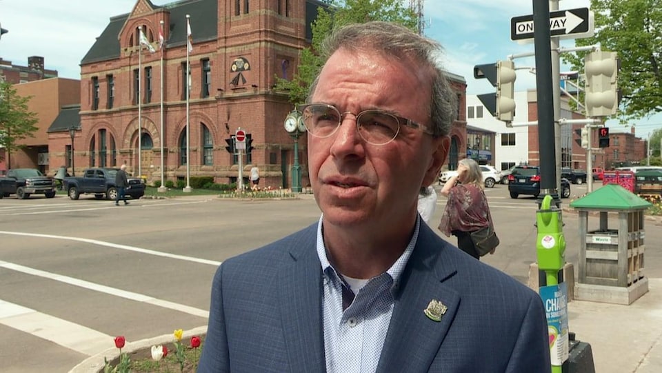 Le maire de Charlottetown, Philip Brown, devant un immeuble brun.