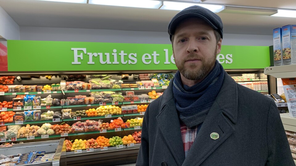 Guillaume Lamoureux se tient devant un rayon d'épicerie. 
