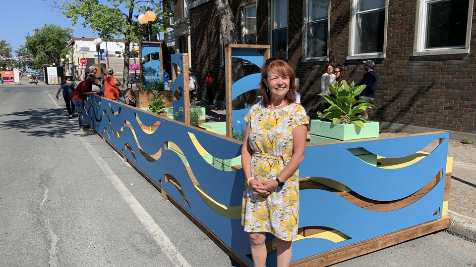 Diane Dallaire est accoté sur la clôture de la terrasse.