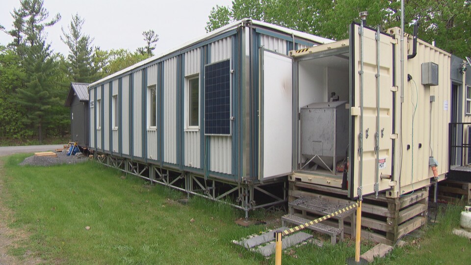 Vue de côté d'un prototype de maison avec un panneau solaire.