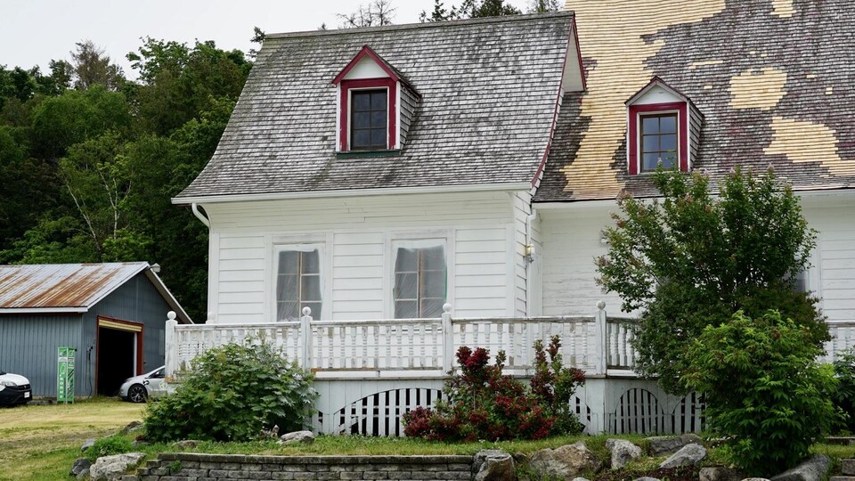 Une des façades la maison, avec le toit qui commence à s'effriter.
