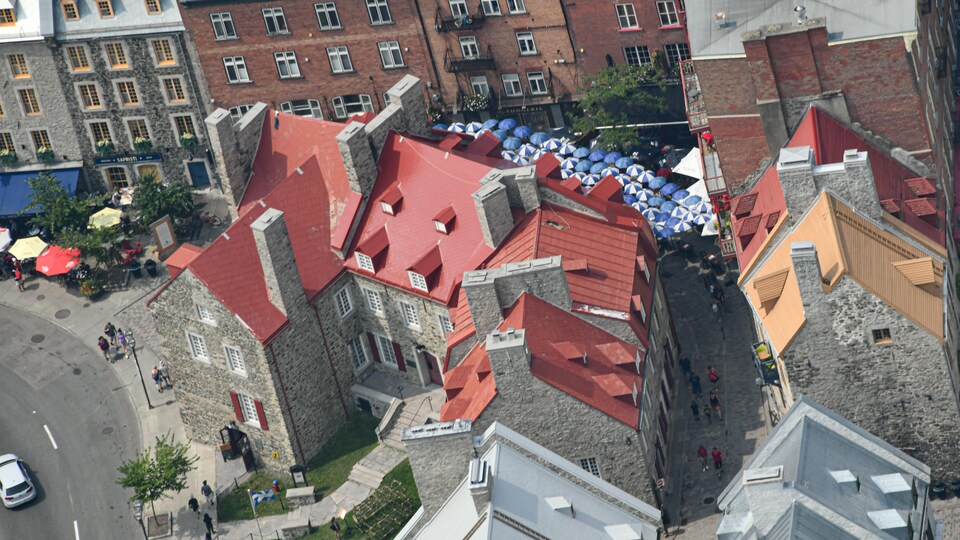 La Maison Chevalier, et les rues environnantes avec l'animation des jours d'été et les parasols aux terrasses, vue des airs.