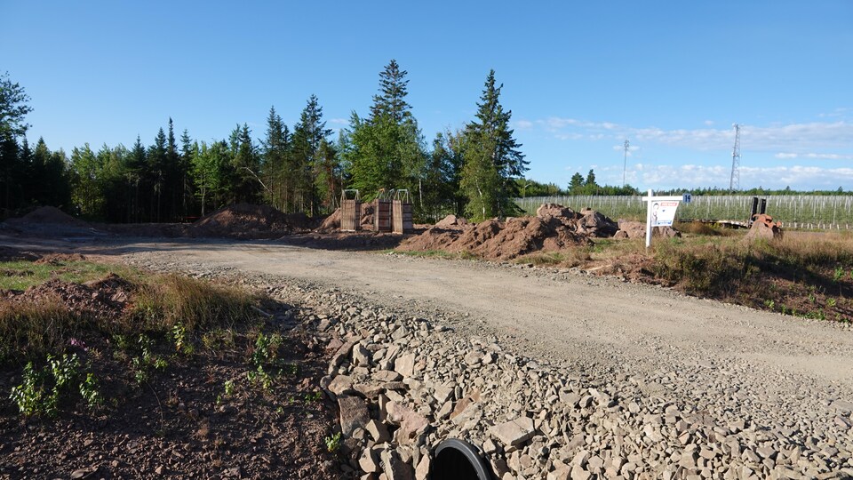 Terrain en chantier, avec affiche à vendre d'un agent immobilier.