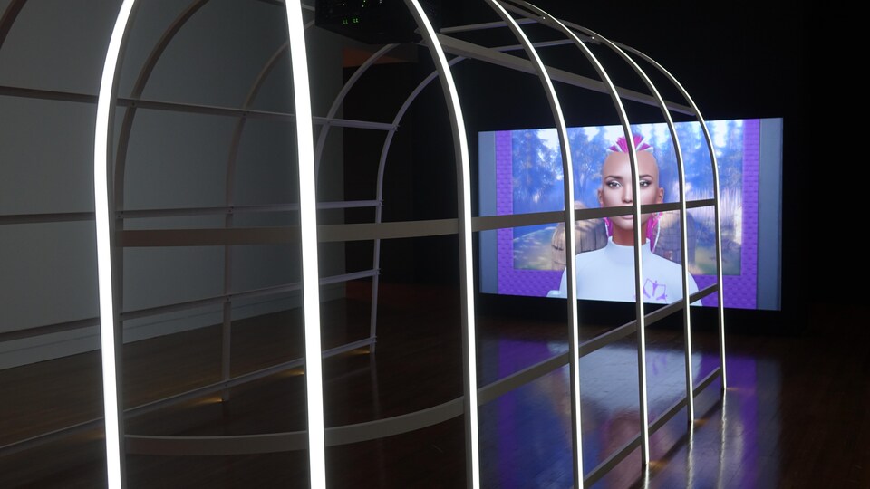 Une installation de métal éclairée au DEL et un écran montrant un personnage 3D coloré.