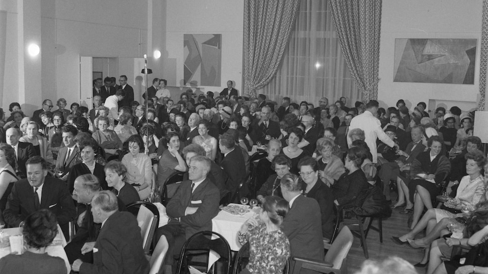Public de l'émission Chez Miville, tenue soignée, dans la grande salle de la Maison du Québec à Paris.