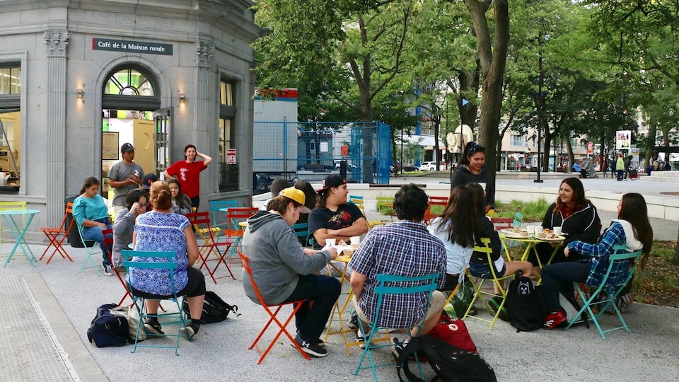 Une vingtaine de jeunes prennent tranquillement le café sur la terrasse du café de la maison ronde, au centre-ville de Montréal.