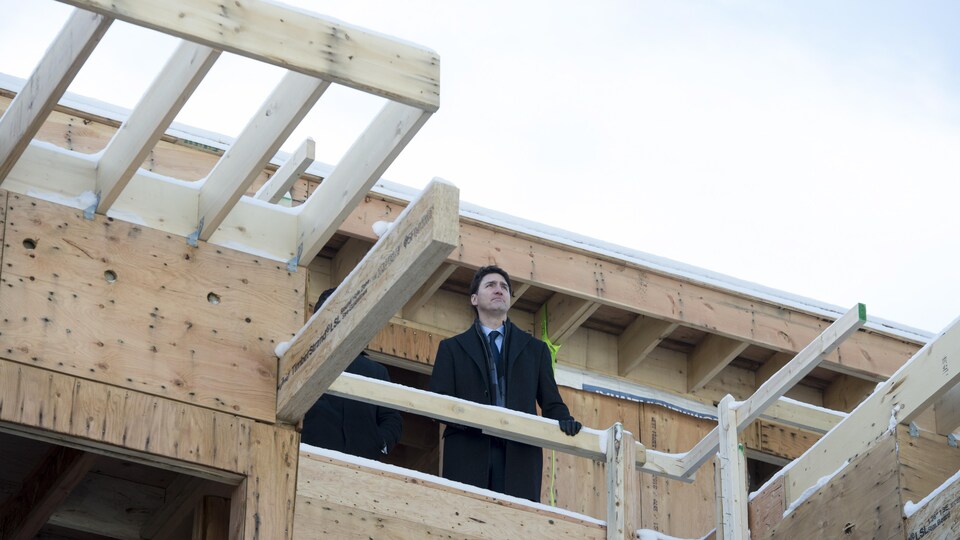 Le premier ministre Justin Trudeau sur le balcon d'un édifice à logement en construction.