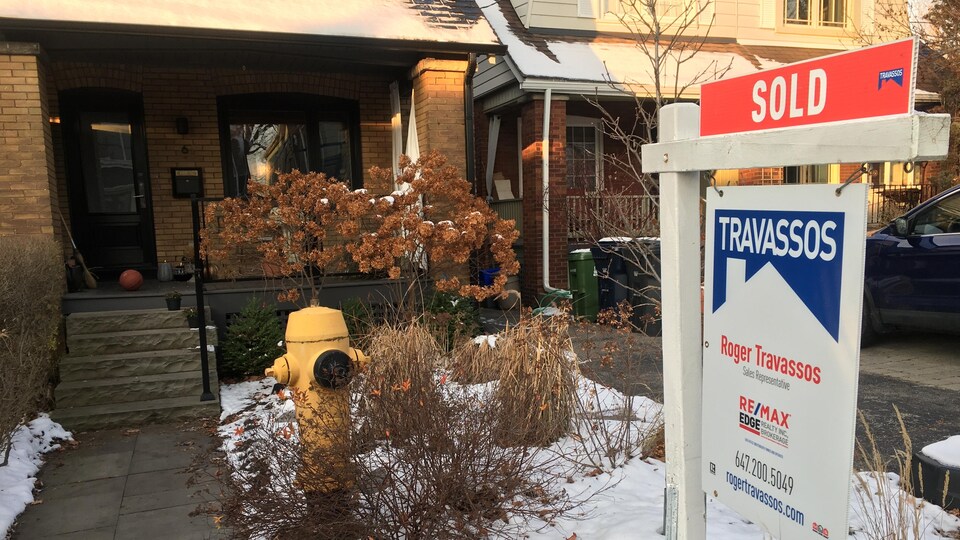 Affiche disant ''vendu'' devant une maison à Toronto.