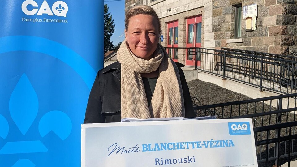 La candidate dehors devant un lutrin.