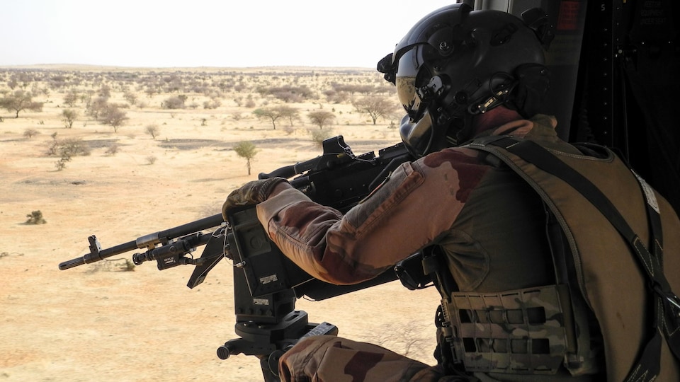 Un soldat français dans la région africaine du Sahel, pointe une mitrailleuse depuis un hélicoptère NH90 entre Gao et Ménaka, au Mali, le 21 mars 2019. 