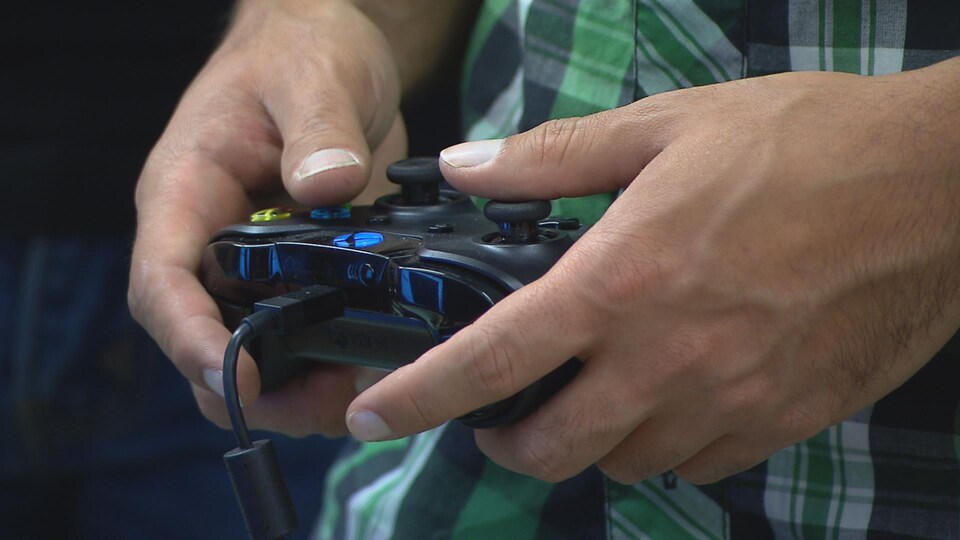 Joueur de jeux vidéo tenant une manette.