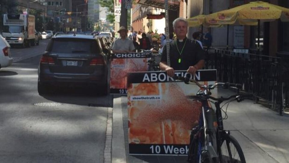 Des membres du Centre canadien pour la réforme en bioéthique manifestent sur la rue College au mois de juillet.