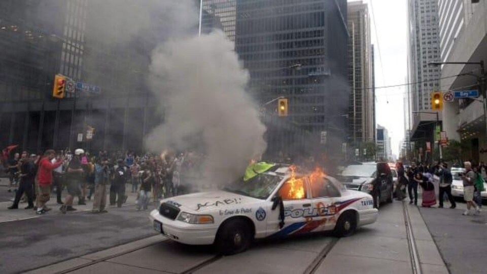 Une voiture de police en flammes.