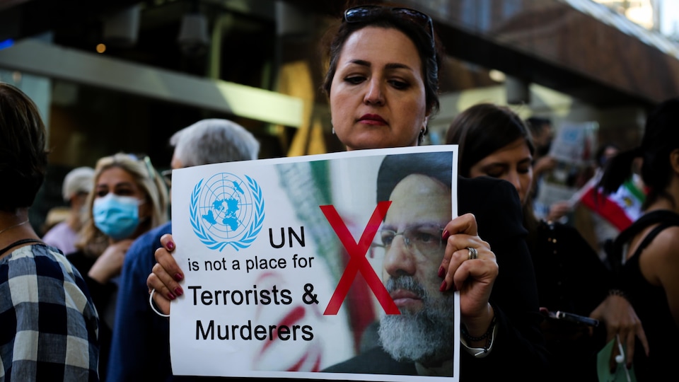 Une femme porte une pancarte avec une photo du président iranien et où l'on peut lire «les Nations unies ne sont pas un endroit pour les terroristes et les meurtriers». 