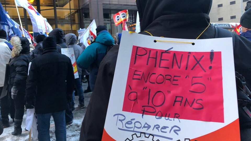 Un manifestant porte une affiche sur laquelle on peut lire : « Phénix encore 5 à 10 ans pour réparer ».