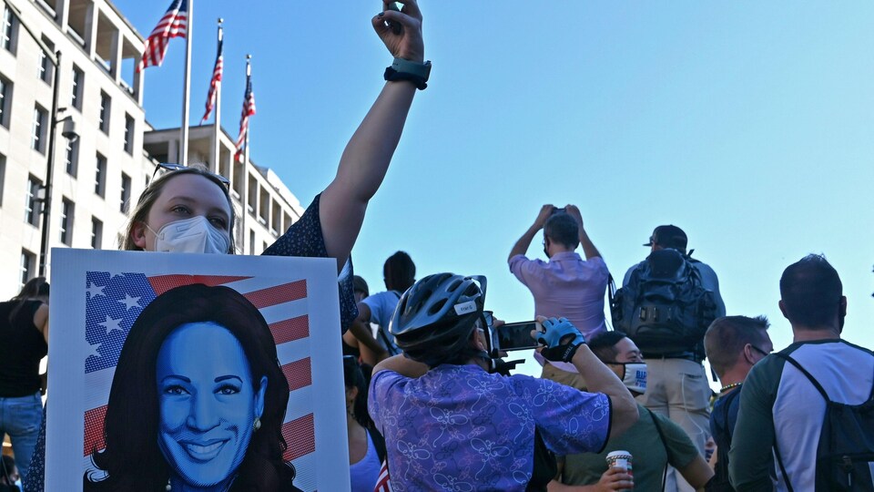 Une manifestante tient une pancarte à l’effigie de Kamala Harris.