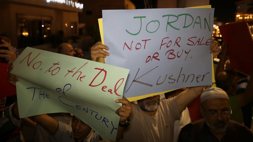 Des hommes tiennent des affiches où on peut lire que la Jordanie n'est pas à vendre ou acheter.