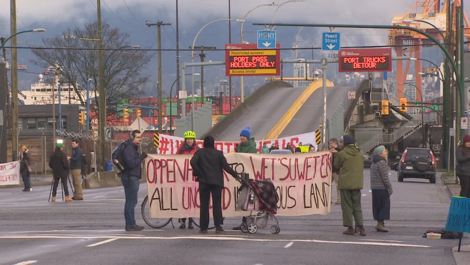 Une dizaine de manifestants rassemblés sur Clark Drive autour d'une banderole bloquent l'entrée au port de Vancouver.