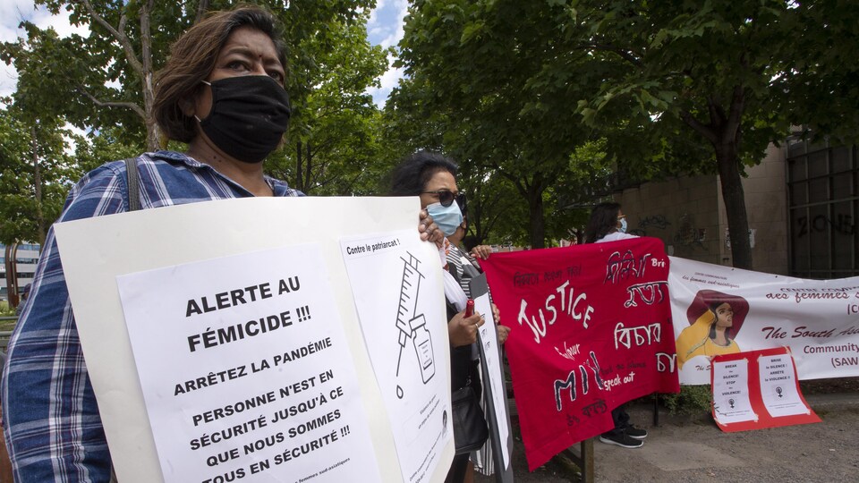 Des femmes tiennent des pancartes avec des slogans dénonçant la violence contre les femmes lors d'une manifestation.