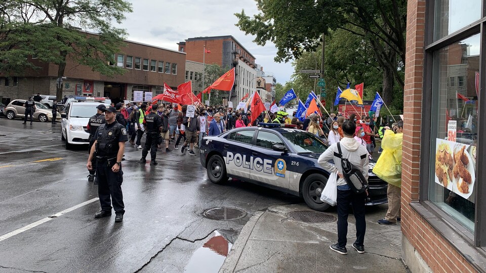 Une manifestations d'une centaine de personnes escortées par des policiers.