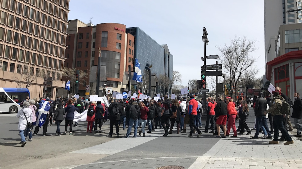 Des manifestants remontent la côte d'Abraham, à Québec, avec drapeaux et pancartes.