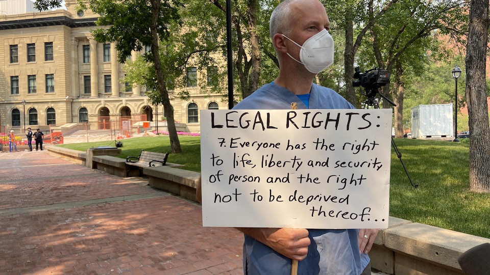 L’urgentologue Joe Vipond avec une pancarte lors d'une manifestation. 