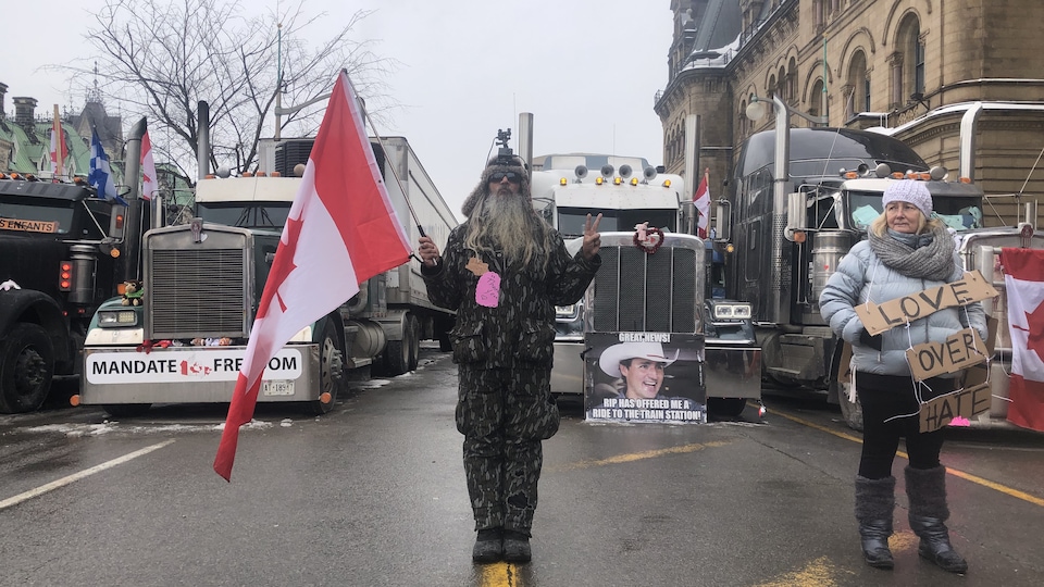 Un homme avec un drapeau devant un camion pendant une manifestation.