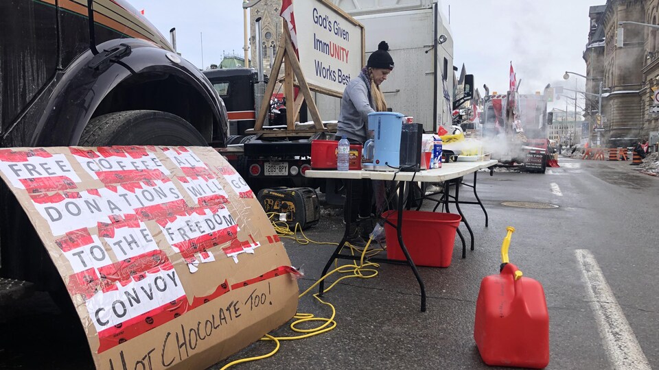 Posters at a protest with someone cooking outside.