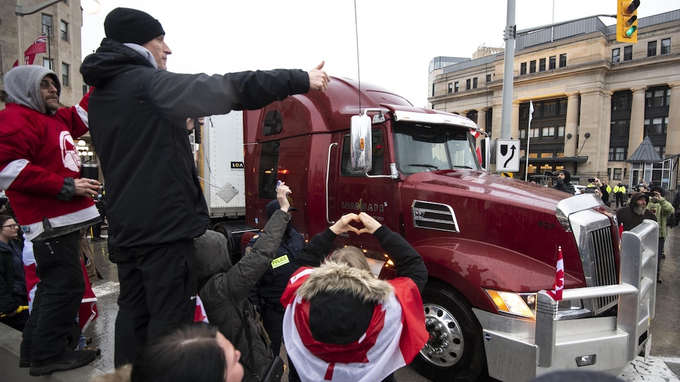 Des manifestants expriment leur soutien à un camionneur.
